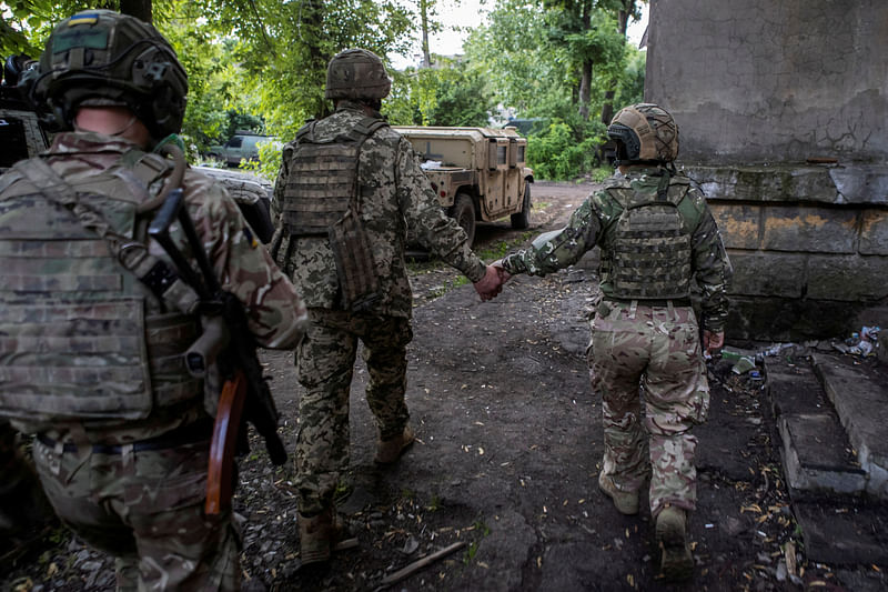 Ukrainian service members walk to an armoured personnel carrier outside of the frontline town of Bakhmut, amid Russia's attack on Ukraine, in Donetsk region, Ukraine on 23 May, 2023