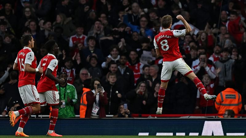 Arsenal's Norwegian midfielder Martin Odegaard (R) celebrates scoring the opening goal during the English Premier League football match between Arsenal and Chelsea at the Emirates Stadium, in London, on 2 May, 2023