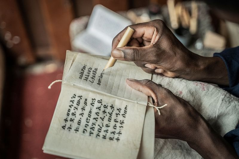 A member of Hamere Berhan initiative writes scriptures in Ge'ez language on parchment made of goat skin in Addis Ababa, Ethiopia on 17 May, 2023.