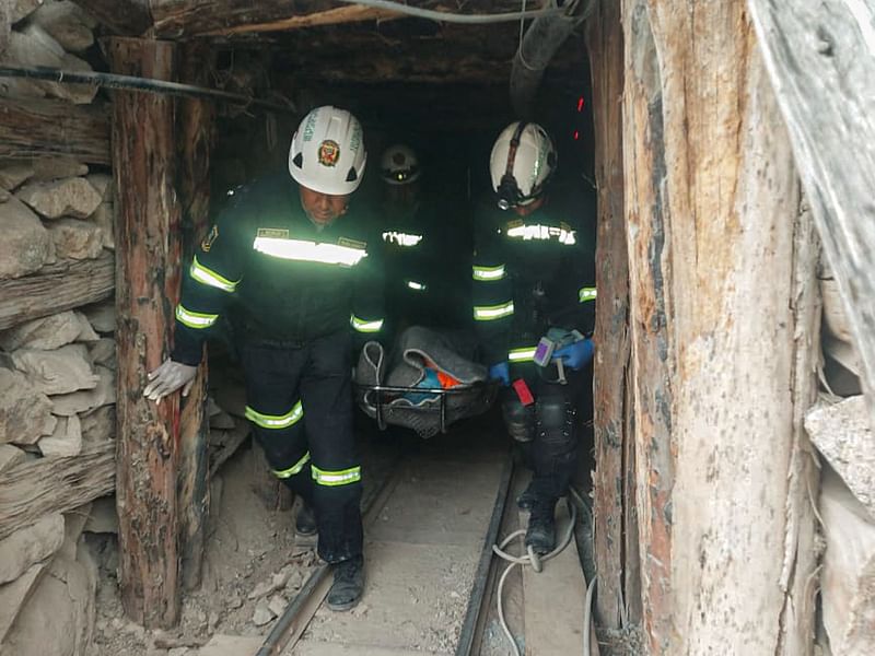 A handout picture released by the Peruvian National Police showing Police officers carrying the remains of one of the victims of a fire at La Esperanza mine in the Yanaquihua district of Arequipa, southern Peru, on May 7, 2023