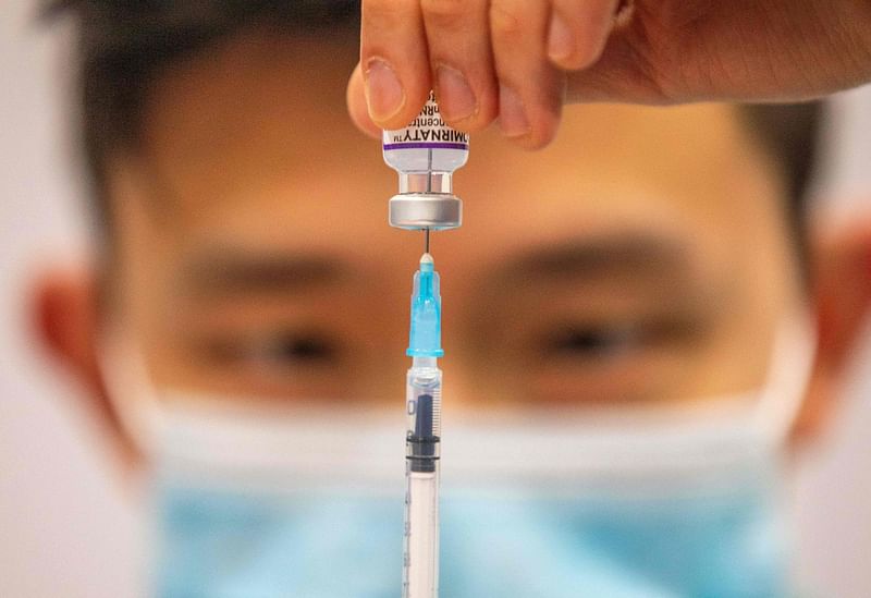 In this file photograph taken on 21 December, 2021, a medical worker prepares a dose of a Covid-19 vaccine at a temporary vaccination centre set up in the Titanic Exhibition Centre in Belfast. The Covid-19 pandemic, which for over three years has killed millions of people, wreaked economic havoc and deepened inequalities, no longer constitutes a global health emergency, the WHO said on 5 May, 2023.