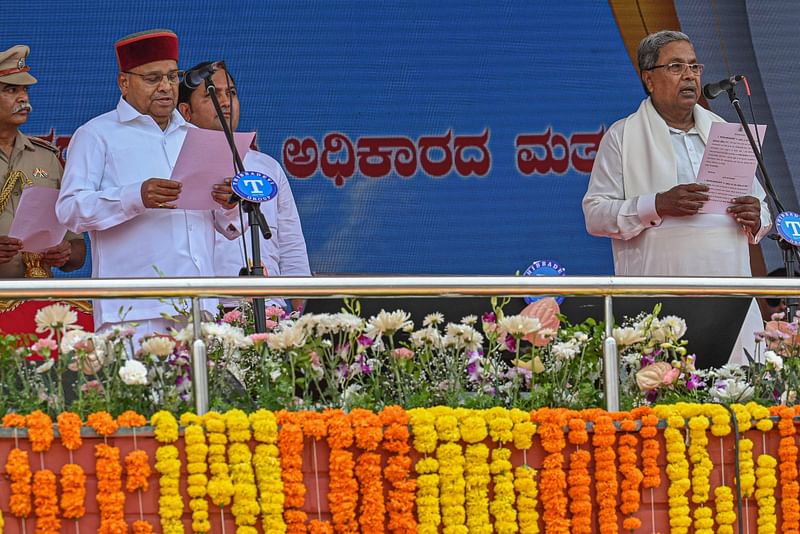 Governor of India's state of Karnataka, Thaawarchand Gehlot (R) administers the oath of office as the chief minister of state to Siddaramaiah during a swearing in function held in Bengaluru on 20 May, 2023