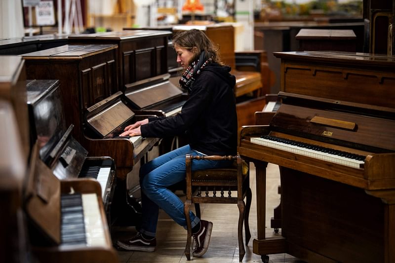 Volunteer staff member Shona MacArthur tries a piano at the Pianodrome, a centre aiming a the refurbishing and repairing pianos located in a former department store near the port of Leith, in Edinburgh, Scotland, on 9 February, 2023