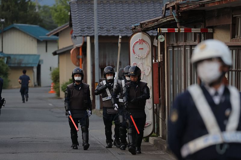 Police officers are seen near the scene of a standoff where a suspect, believed to be a farmer in his 30s, was holed up inside a building in the Ebe area of Nakano, Nagano Prefecture, early morning on 26 May, 2023.