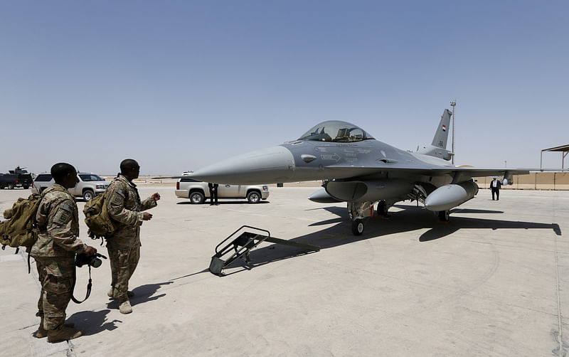 US Army soldiers look at an F-16 fighter jet during an official ceremony to receive four such aircraft from the United States, at a military base in Balad, Iraq, on 20 July, 2015