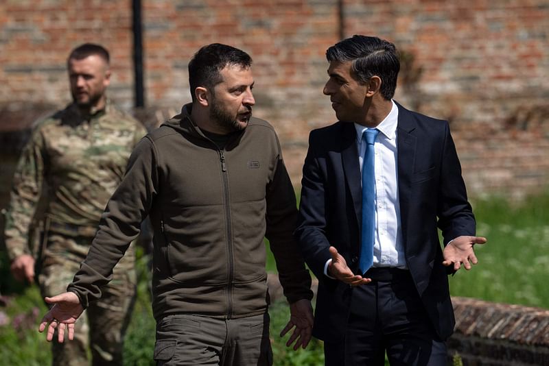 Britain’s Prime Minister Rishi Sunak (R) talks with Ukraine’s President Volodymyr Zelensky, as he walks with him to a waiting Chinook helicopter following their meeting at Chequers, the prime minister’s official country residence, near Ellesborough, northwest of London, on 15 May, 2023. Ukrainian President Volodymyr Zelensky met in Britain on Monday with Prime Minister Rishi Sunak, who pledged “hundreds” of both air defence missiles and long-range attack drones to fend off Russia’s invasion