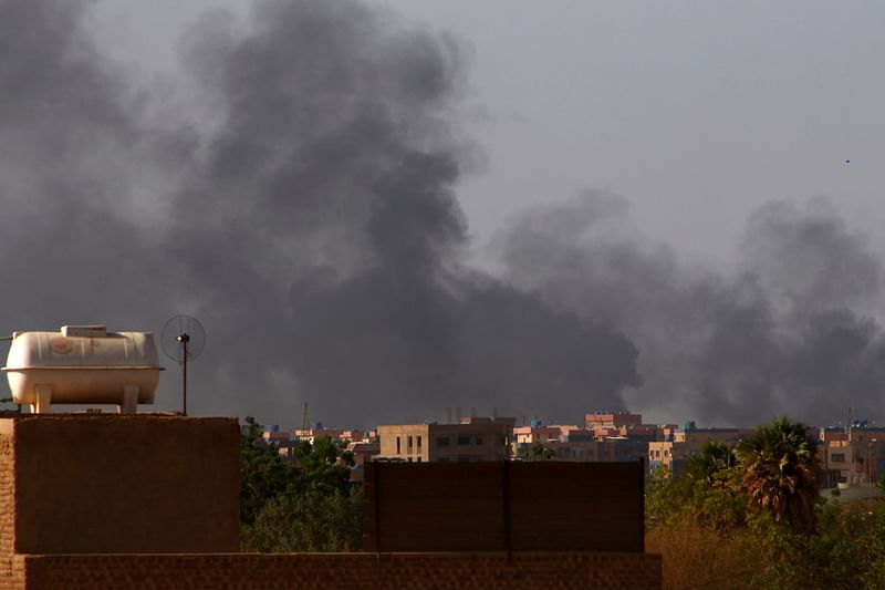 Smoke billows in the distance in Khartoum on May 22, 2023, as fighting between two rival generals persists. Gunfire and explosions rocked Sudan's capital on May 22 morning hours before a one-week humanitarian ceasefire was due to take effect, the latest after a series of truces that have all been violated.