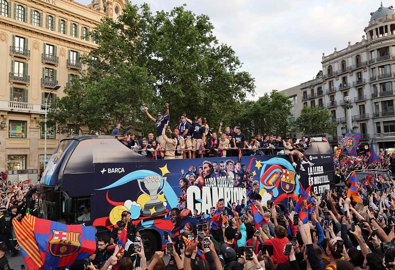 The players and staff of FC Barcelona men football team parade aboard a open-top bus followed by the women's team (out of frame), to celebrate their La Liga titles in Barcelona on 15 May 2023