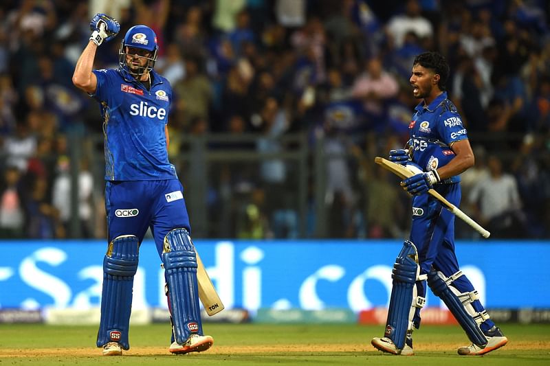 Mumbai Indians' Tim David (L) and Tilak Varma celebrate their win at the end of the Indian Premier League (IPL) Twenty20 cricket match between Mumbai Indians and Rajasthan Royals at the Wankhede Stadium in Mumbai on 30 April, 2023