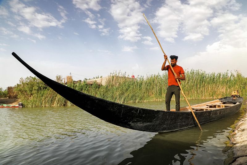 In this picture taken on 29 April, 2023 a man rows a newly-constructed traditional "meshhouf" wooden boat in the area of al-Huwair in the sub-district of al-Madinah in Iraq's southern Basra province.