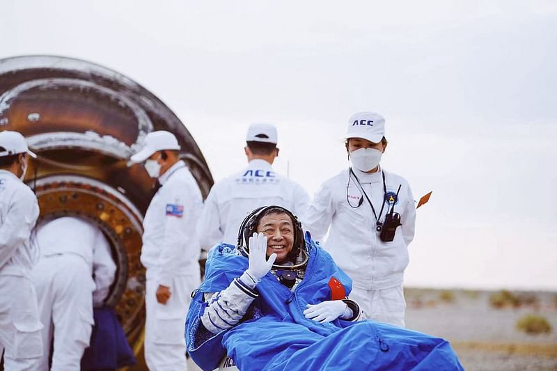 aikonaut Deng Qingming waves as he leaves the capsule of the Shenzhou-15 spaceship after landing in China's Inner Mongolia on 4 June, 2023.