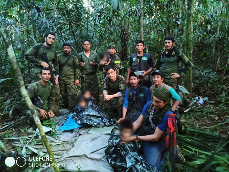 Members the army pose with four Indigenous children after spending more than a month lost in the Colombian Amazon rainforest following a small plane crash, in Colombia's Guaviare jungle on 9 June 2023.