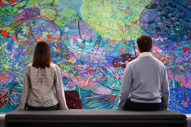 Gallery assistants look at the painting "And willingly imprinting the memory of my mistakes, 2023" by British painter Jade Fadojutimi during a press preview of the exhibition "To Bend the Ear of the Outer World: Conversations on contemporary abstract painting" at Gagosian Grosvenor Hill gallery in central London on 1 June, 2023.