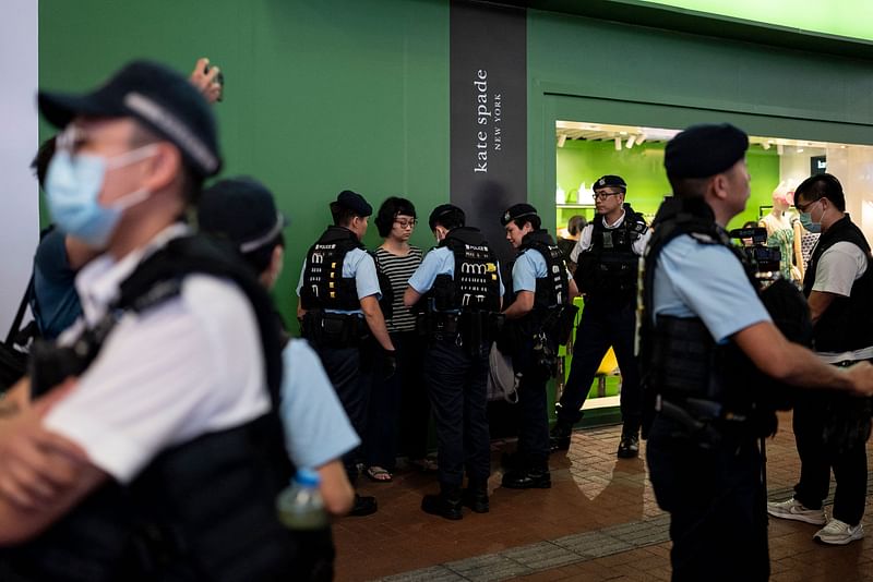 Police stop and search performance artist Chan Meitung (C) before arresting her in Causeway Bay near Victoria Park in Hong Kong on June 3, 2023, a day before the anniversary of the 1989 Tiananmen Square crackdown.