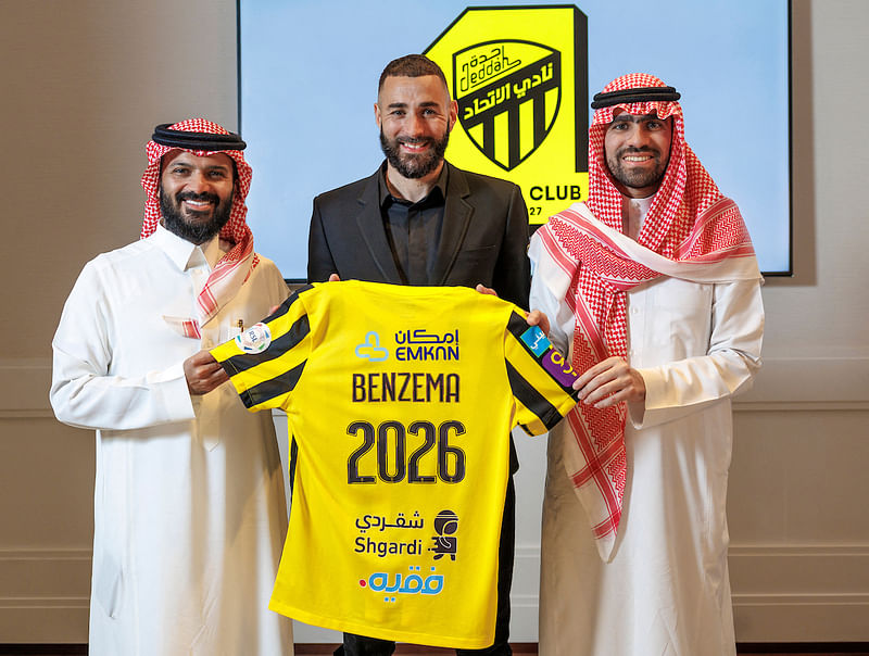 In this handout picture release by the Saudi Pro League on 6 June 2023, French footballer Karim Benzema holds the jersey of Saudi Arabia's Al-Ittihad club as he poses for a picture flanked by Al-Ittihad members, in Madrid