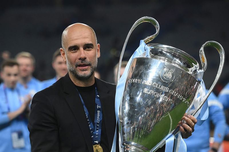 Manchester City's Spanish manager Pep Guardiola celebrates with the trophy after winning the UEFA Champions League final between Inter Milan and Manchester City at the Ataturk Olympic Stadium in Istanbul on 10 June 2023