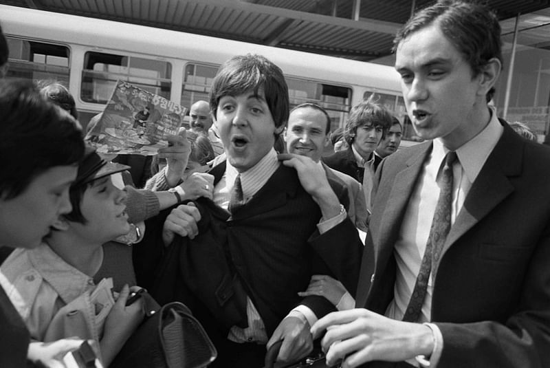 Fans surround Beatles Paul McCartney (C) and George Harrison (2R) upon their arrival at Orly airport on 20 June, 1965, before their concert at the Palais des Sports the same evening. When the Beatles broke up more than 50 years ago, devastated fans were left yearning for more. Now, artificial intelligence is offering just that.