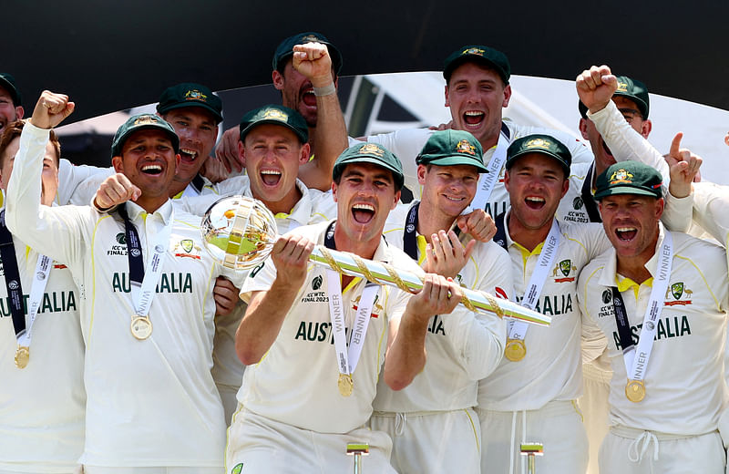 Australia's Pat Cummins celebrates with the ICC Test Mace on the podium along with teammates after winning the World Test Championship final