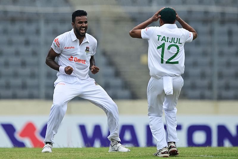 Bangladesh’s Ebadot Hossain (L) celebrates with teammate Taijul Islam after the dismissal of Afghanistan's Rahmat Shah (not pictured) during the second day of the Test cricket match between Bangladesh and Afghanistan at the Sher-e-Bangla National Cricket Stadium in Dhaka on 15 June, 2023