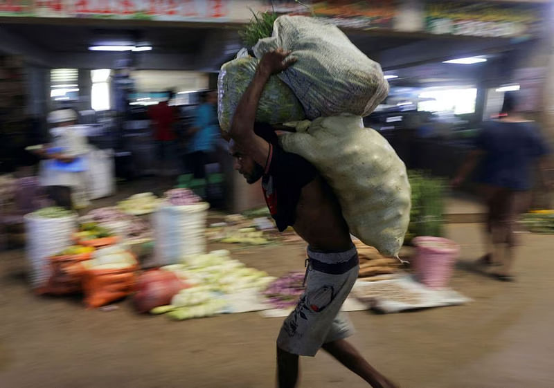 A worker carries sacks of vegetables at a wholesale market, as Sri Lanka's key inflation rate eases to 25.2 per cent in May, in Colombo, Sri Lanka on 1 June, 2023.