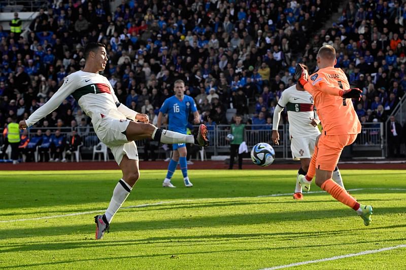 Portugal's forward Cristiano Ronaldo scores past Iceland's goalkeeper Runar Runarsson during the UEFA Euro 2024 group J qualification match between Iceland and Portugal in Reykjavik on 20 June 2023