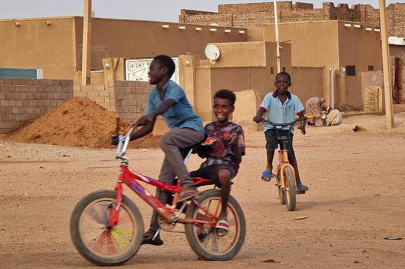 Children cycle along a street in Khartoum on 14 June, 2023