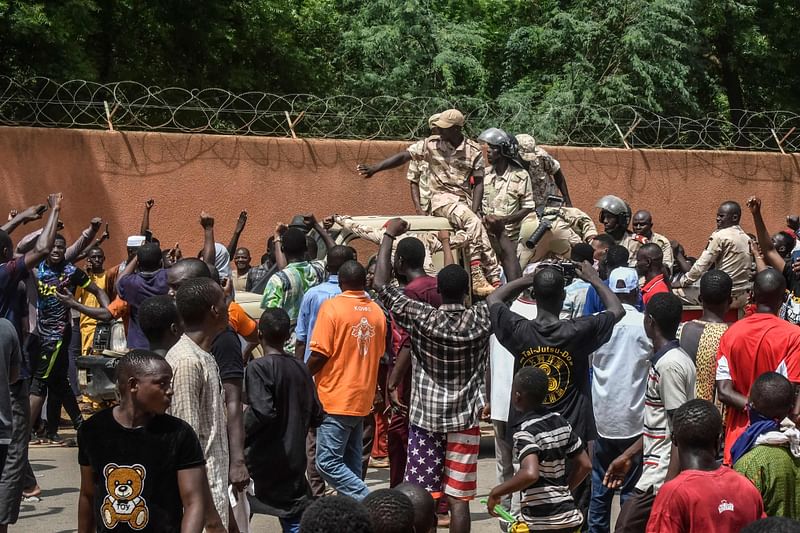 Protesters cheer Nigerien troops as they gather in front of the French Embassy in Niamey during a demonstration that followed a rally in support of Niger's junta in Niamey on July 30, 2023