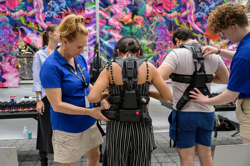 Concertgoers get fitted for haptic suits created for the deaf by Music: Not Impossible, during an outdoor concert at Lincoln Center on 22 July, 2023, in New York City.