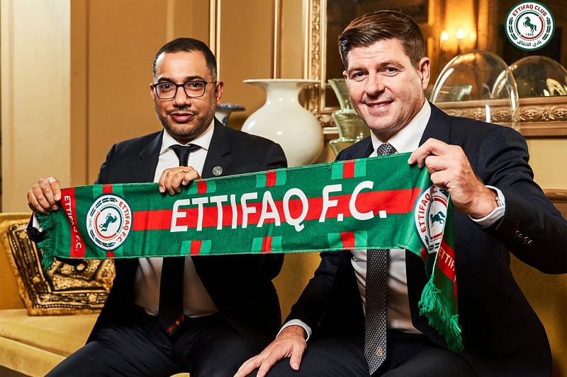 This handout picture released by Saudi Arabia's al-Ettifaq football club on 3 July 2023 shows Ettifaq's new English manager Steven Gerrard with the club's President Khaled al-Debel after signing with them in London