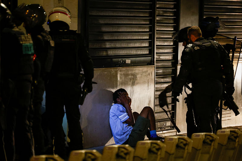 Police identify a young person during the fifth night of protests following the death of Nahel, a 17-year-old teenager killed by a French police officer in Nanterre during a traffic stop, in the Champs Elysees area, in Paris, France, July 2, 2023