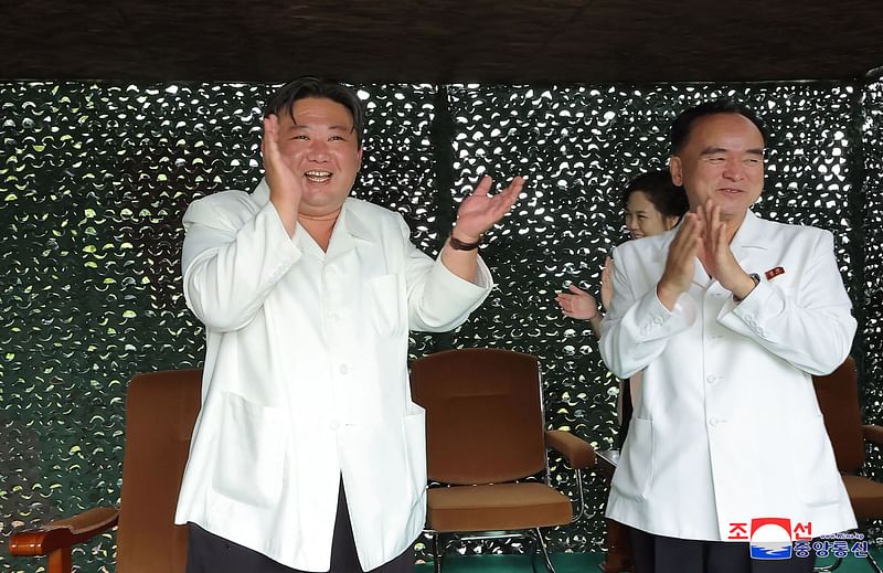 This picture taken on July 12, 2023 and released by North Korea's official Korean Central News Agency (KCNA) on 13 July, 2023 shows North Korea's leader Kim Jong Un (L) and his wife Ri Sol Ju (C obscured) applauding the test firing of a new intercontinental ballistic missile (ICBM) "Hwasong-18" at an undisclosed location in North Korea