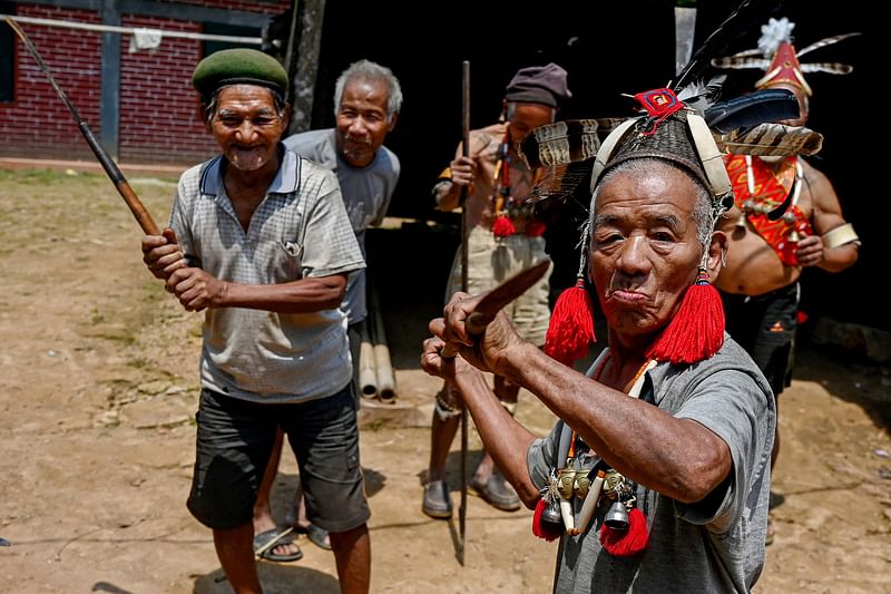 This photograph taken on April 8, 2023 shows Konyak tribesmen gesturing during a community gathering in Hongphoi village in the Mon district of India's Nagaland state. Once, the way to get ahead among India's Konyak warriors was by chopping off an enemy's skull