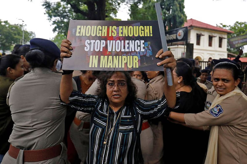 A demonstrator holds up a placard, as police officers detain others during a protest against the alleged sexual assault of two tribal women in the eastern state of Manipur, in Ahmedabad, India, on 23 July, 2023.