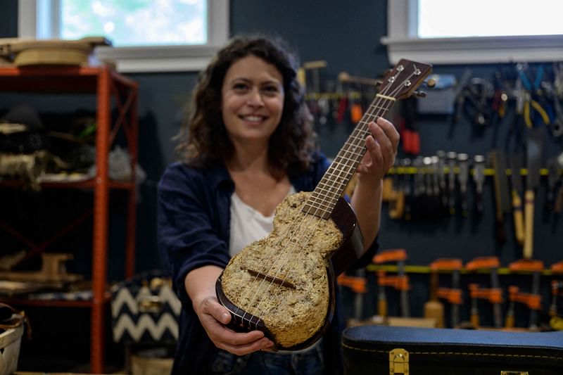 French luthier Rachel Rosenkrantz plays a ukulele made using mycelium in her studio on 21 June, 2023, in Providence, Rhode Island. Leave mushroom spores in a mold for a couple weeks and they'll bloom into a puffy material akin to brie, says Rosenkrantz, a sustainability-minded guitar-maker innovating with bio-materials. Once her mycelium, the root-like structure of fungus that produces mushrooms, mimics the rind of a soft-ripened cheese Rosenkrantz dehydrates it into a lightweight, biodegradable building material -- in this case, a guitar-body.