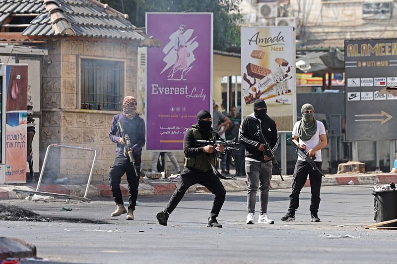 Palestinian armed militants fire at Israeli armoured vehicles in the occupied West Bank city of Jenin on July 3, 2023