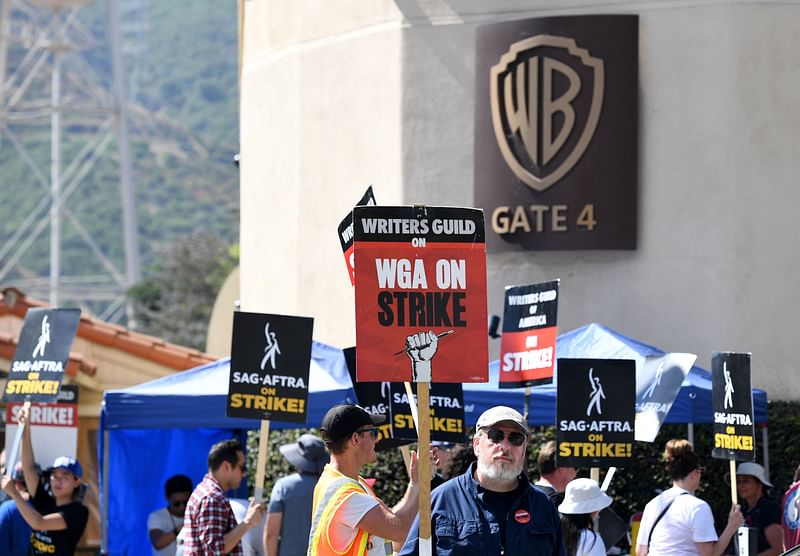 Members of the Writers Guild of America and the Screen Actors Guild walk a picket line outside of Warner Bros Studio in Burbank, California, on 26 July, 2023.