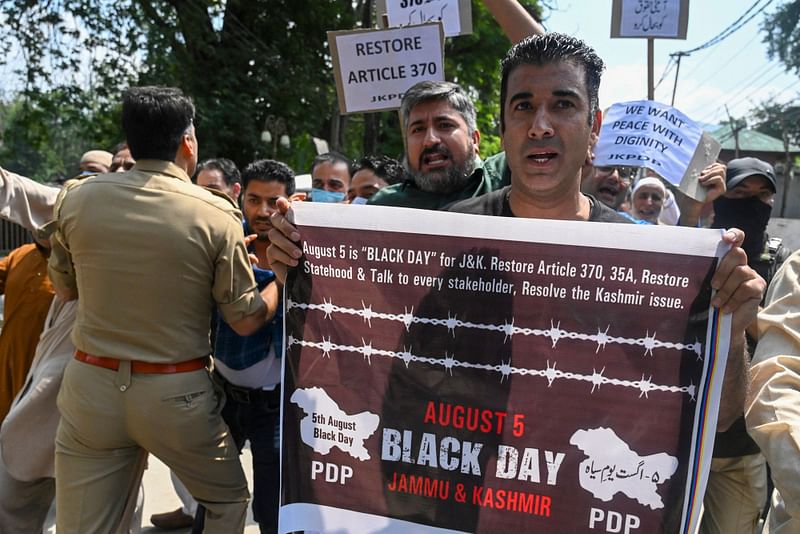 Police (L) stop activists and supporters of Peoples Democratic Party (PDP) as they protest against the scrapping of Article 370 of Jammu and Kashmir, in Srinagar on August 5, 2022