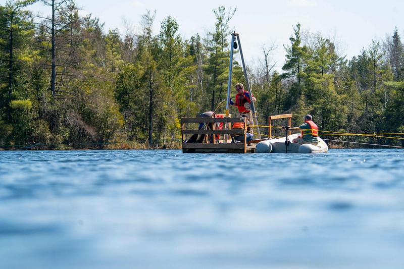 Tim Patterson (C), Professor of Geology at Carleton University, left, leads a team of scientists as they retrieve a probe from the bottom of Crawford Lake while gathering sediment layer samples at Crawford Lake near Milton, Ontario, Canada, April 12, 2023