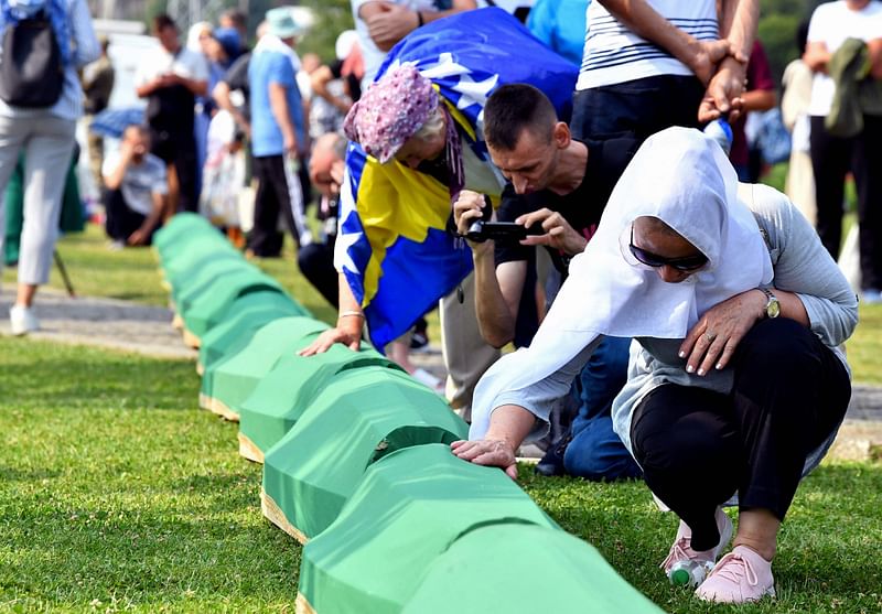 A Bosnian Muslim woman, survivor of the Srebrenica 1995 massacre mourns near the casket containing the remains of a relative and victim of the Srebrenica 1995 massacre, at the memorial cemetery in the village of Potocari, near Eastern-Bosnian town of Srebrenica, on 11 July, 2023