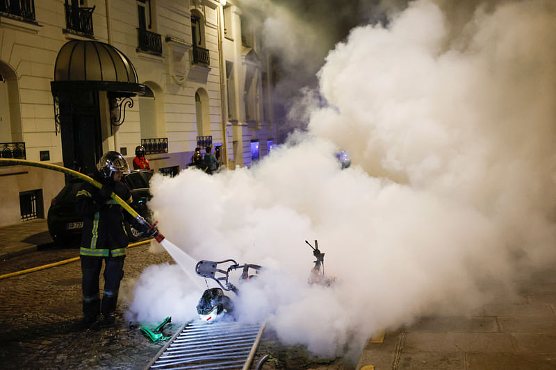 A French firefighter works to extinguish a burning motorbike during the fifth day of protests following the death of Nahel, a 17-year-old teenager killed by a French police officer in Nanterre during a traffic stop, in Paris, France, July 2, 2023