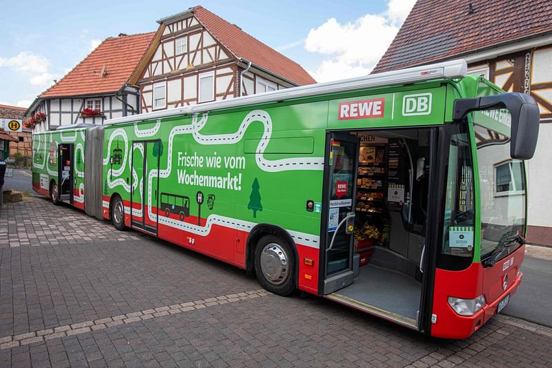 A REWE shopping supermarket bus delivering daily needs is stationed at a place in Haddamar near Fritzlar, central Germany, on 6 July, 2023. The supermarket-on-wheels is a pilot project between Germany's third-largest food retailer REWE and the Deutsche Bahn rail and transport company.