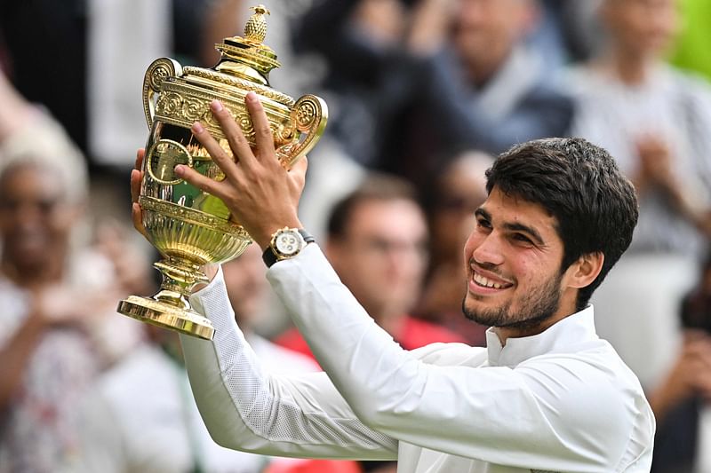 Spain's Carlos Alcaraz raises the winner's trophy after beating Serbia's Novak Djokovic during their men's singles final on the last day of the 2023 Wimbledon Championships at The All England Tennis Club in Wimbledon, London on 16 July 2023