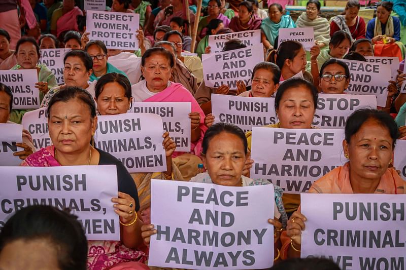 Women hold placards during a demonstration over sexual violence against women and for peace in the ongoing ethnic violence in India's north-eastern state of Manipur, in Imphal on 21 July, 2023