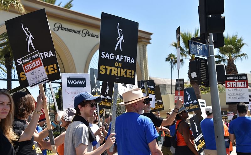 Members of the Writers Guild of America and the Screen Actors Guild walk a picket line outside Paramount Studios in Los Angeles, California, on 14 July, 2023.