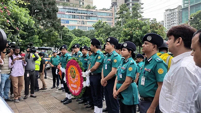 DMP lays wreaths before the mural of two police officers killed in the Holey Artisan attack