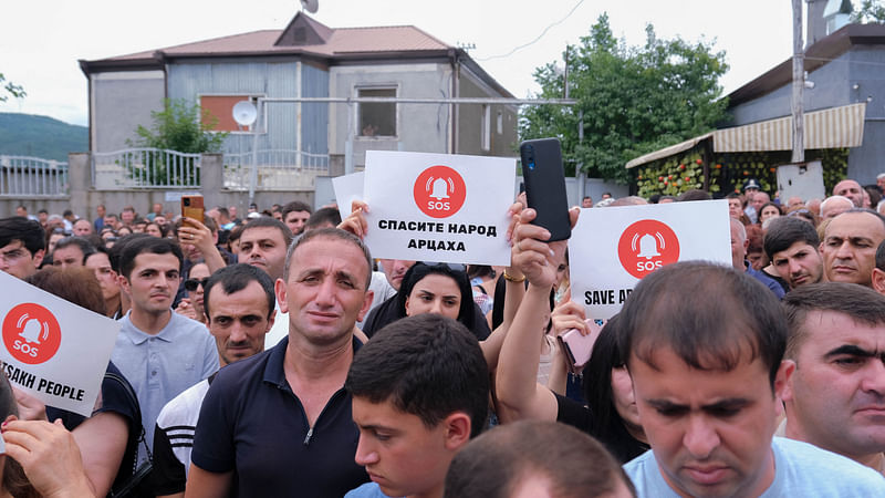 Demonstrators hold placards reading "Sos, save the people of Artsakh" during a rally to demand the reopening of a blockaded road linking the Nagorno-Karabakh region to Armenia and to decry crisis conditions in the region, in Stepanakert on July 14, 2023