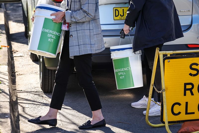 Australian Border Force agents gather equipment outside an apartment block after they raided it earlier amid media reports "nuclear isotopes" had been found, in Sydney on 17 August, 2023.