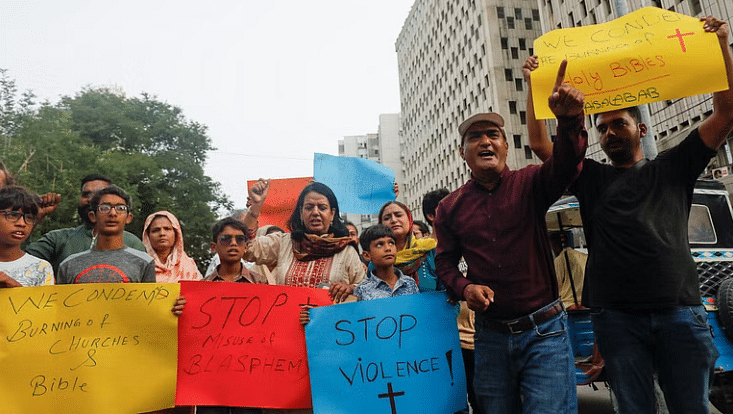 Members of the Christian community chant slogans as they hold placards to condemn the attacks on churches and houses in Jaranwala town of Faisalabad during a protest in Karachi, Pakistan, on 16 August, 2023.