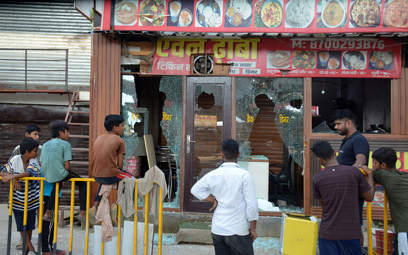 People stand in front of an eatery after it was vandalised by a mob following clashes between Hindu and Muslims that erupted on Monday, in Gurugram, on the outskirts of New Delhi, India, August 1, 2023