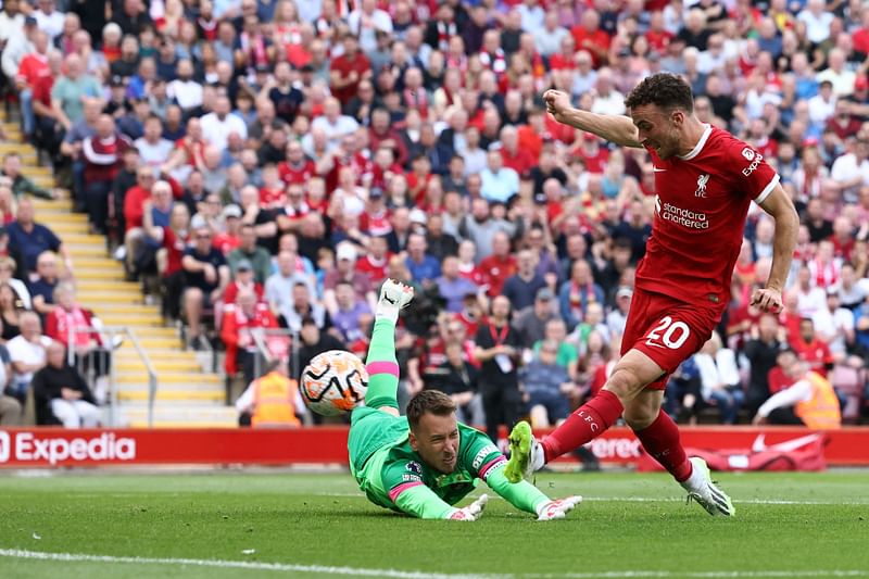 Liverpool's Portuguese striker #20 Diogo Jota (R) scores past Bournemouth's Brazilian goalkeeper #01 Neto for their third goal during the English Premier League football match between Liverpool and Bournemouth at Anfield in Liverpool, north west England on August 19, 2023